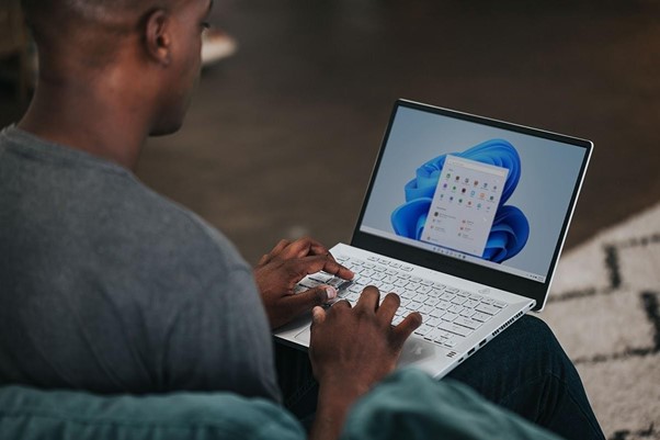 man in gray long sleeve shirt using Windows 11 computer man in gray long sleeve shirt using Windows 11 computer