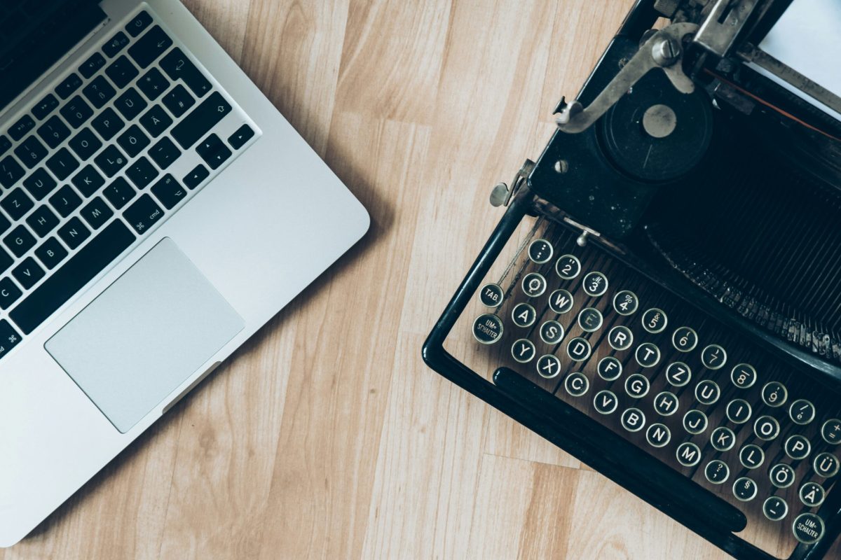 a laptop and a typewriter on a wooden table